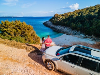 A man and woman hugging, overlooking a cove